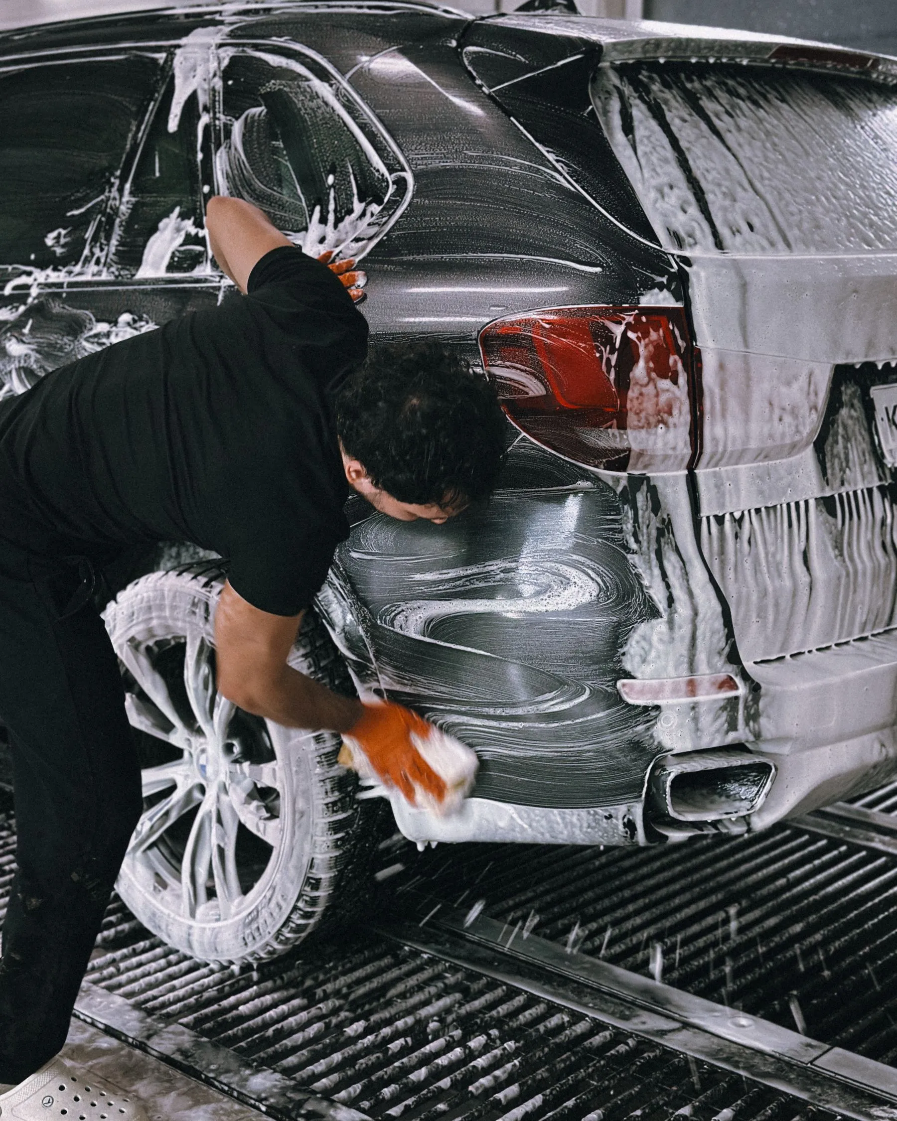 A hand washing the exterior of a vehicle